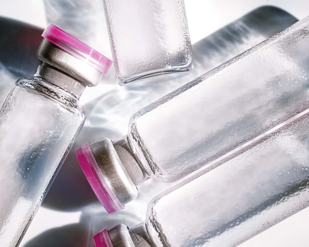 Syringes and labeled peptide vials on white surface representing personalized hormone and metabolism therapy treatments
