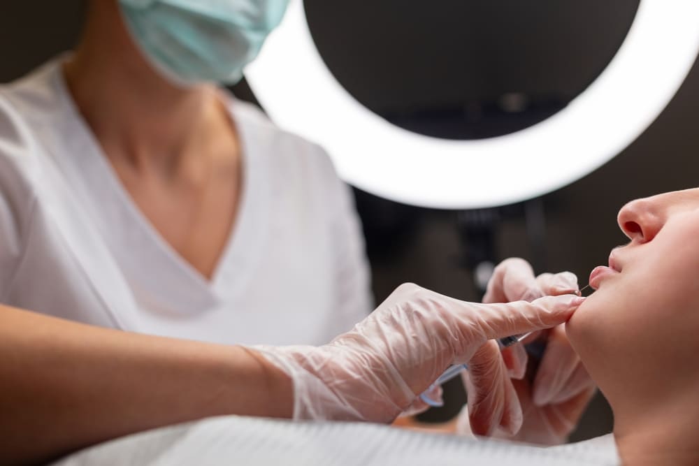 Practitioner performing facial injection while explaining how long Botox and fillers last and factors affecting results