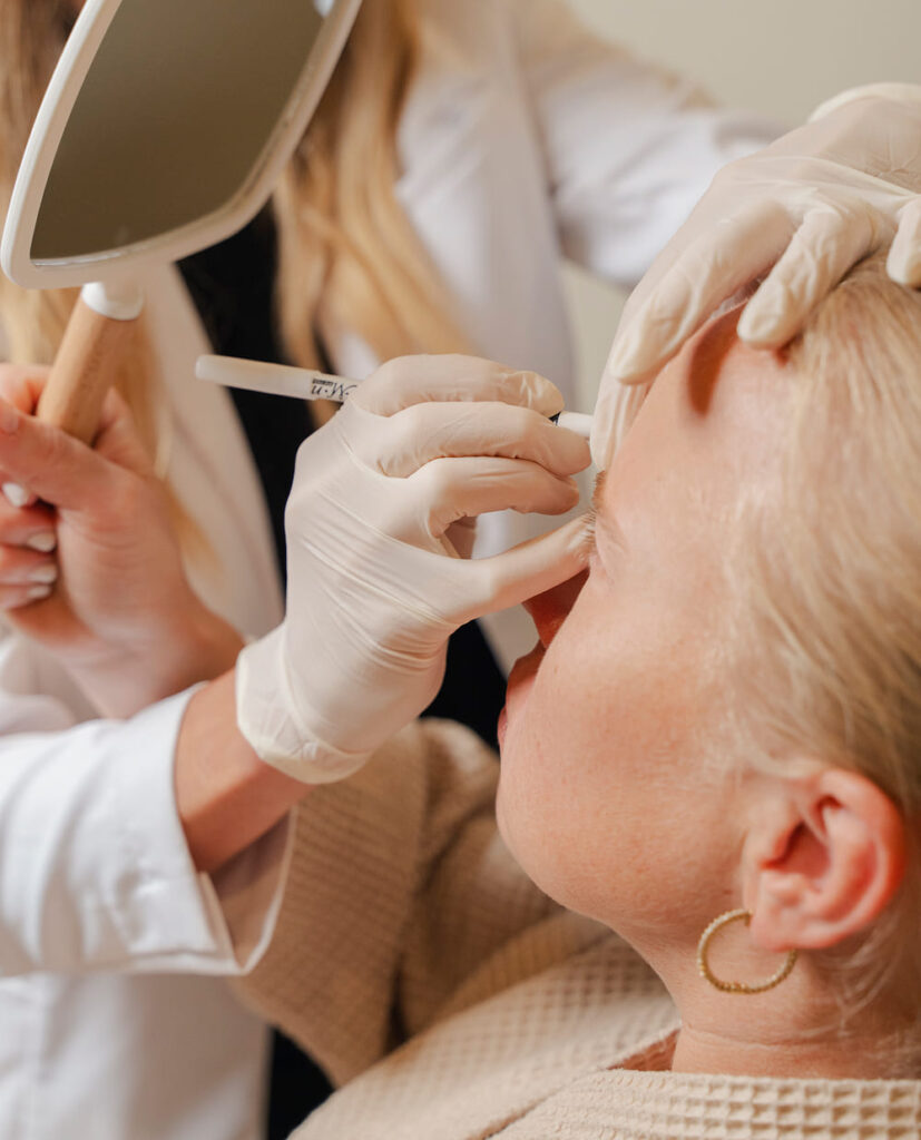 Practitioner injecting forehead while explaining dynamic and static wrinkles, highlighting differences in Botox and filler treatments