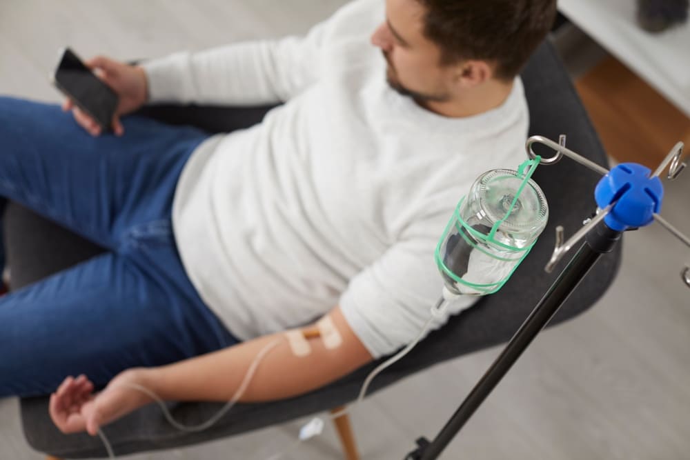 Man receiving IV therapy while resting, illustrating considerations around consecutive treatments and safe usage guidelines